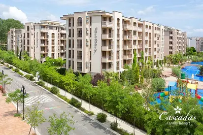 an apartment building with a garden and a pool at Cascadas Family Resort in Sunny Beach