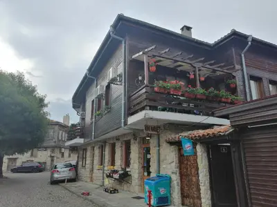 a building with a balcony with flowers on it at Guest House Juja in Nesebar