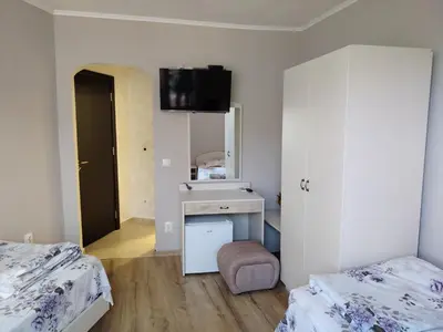 a room with two beds and a sink and a mirror at Guest House Juja in Nesebar