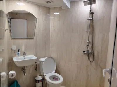 a bathroom with a toilet and a sink and a shower at Guest House Juja in Nesebar