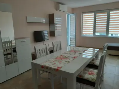 a kitchen and dining room with a table and chairs at Апартаменти и стаи Мони Холидейс in Tsarevo