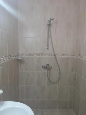 a shower with a hose in a bathroom at Апартаменти и стаи Мони Холидейс in Tsarevo