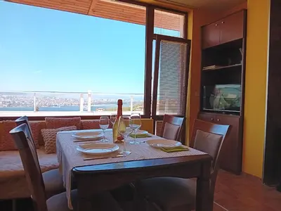 a dining room with a table with wine glasses at Apartament Zaliva in Varna City