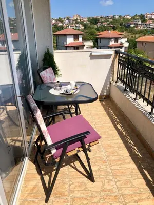 a table and chairs sitting on a balcony with a view at PANORAMA SUNRISE Byala Studio - rest and seaside recreation in Byala