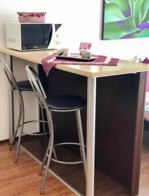 a desk with two chairs and a microwave at PANORAMA SUNRISE Byala Studio - rest and seaside recreation in Byala