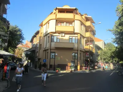 a yellow building on the side of a street at Hristovi Apartments & Studios in Pomorie