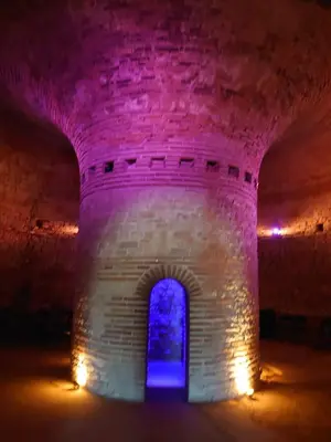 a lit up archway in a castle at night at Hristovi Apartments & Studios in Pomorie