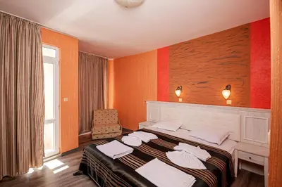 a bedroom with a bed with towels on it at Family Hotel Paros in Pomorie
