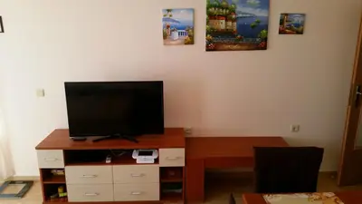 a living room with a flat screen tv on a wooden entertainment center at Aqua Dreams - new wifi in Sveti Vlas