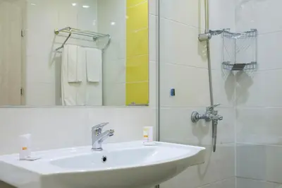 a bathroom with a sink and a shower with a mirror at Hotel Garden Nevis - All Inclusive in Sunny Beach