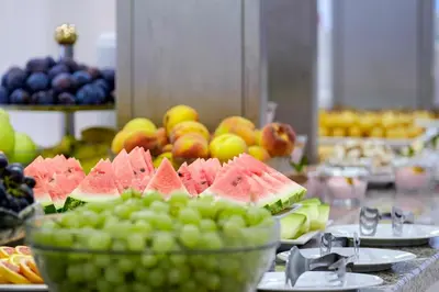 a buffet of fruits and vegetables on a table at Hotel Garden Nevis - All Inclusive in Sunny Beach