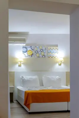 a bedroom with a bed with an orange blanket at Hotel Garden Nevis - All Inclusive in Sunny Beach