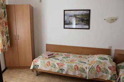 a bedroom with a bed with a quilt on it at Hotel Radik in Sozopol