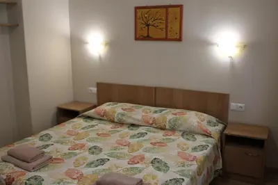 a bedroom with a bed with a floral bedspread at Hotel Radik in Sozopol
