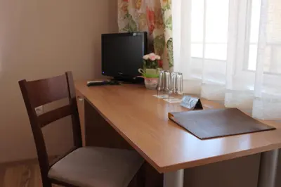 a wooden desk with a television and a chair at Hotel Radik in Sozopol