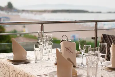 a table with glasses and plates and napkins on it at Family Hotel Sunrise in Lozenets