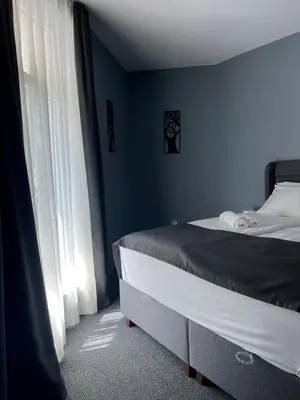 a bedroom with a bed and a blue wall at Family Hotel Sunrise in Lozenets