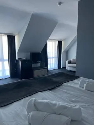 a large white room with a bed and some windows at Family Hotel Sunrise in Lozenets