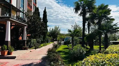a garden with palm trees and flowers next to a building at Chateau del Marina Apart Complex in Nesebar
