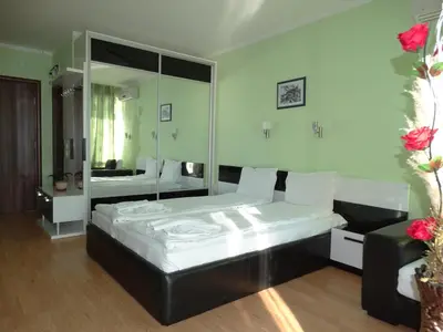 a bedroom with a large bed and a mirror at Chateau del Marina Apart Complex in Nesebar