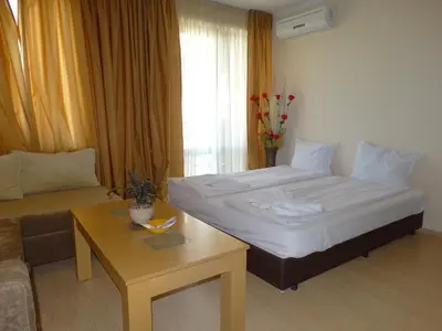 a bedroom with a bed and a couch and a table at Chateau del Marina Apart Complex in Nesebar