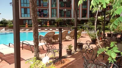 a patio with chairs and a pool in a building at Chateau del Marina Apart Complex in Nesebar