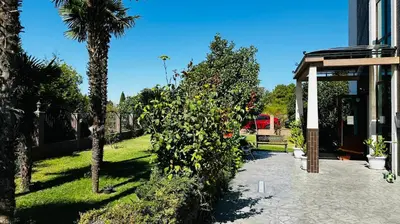 a garden with a palm tree next to a building at Chateau del Marina Apart Complex in Nesebar