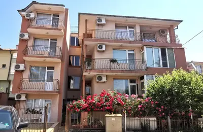 an apartment building with flowers in front of it at Guest House Georgieva Ravda in Ravda