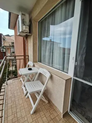 a white chair and a table on a balcony at Guest House Georgieva Ravda in Ravda