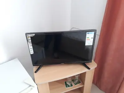 a flat screen tv sitting on top of a wooden stand at Mappy Holidays Aparthotel in Sozopol