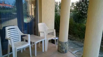 two white chairs and a table on a porch at Mappy Holidays Aparthotel in Sozopol