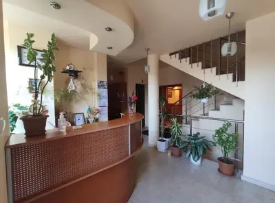 a lobby with potted plants in a building at Family Hotel Denica in Obzor