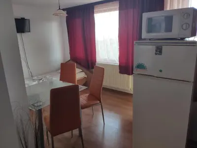 a kitchen with a table and a refrigerator with a microwave at Family Hotel Denica in Obzor