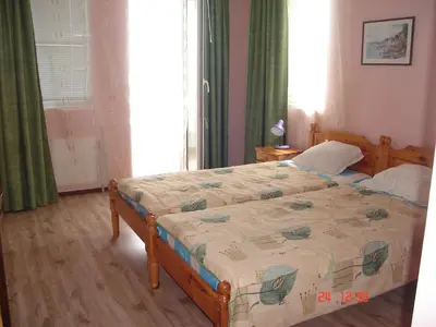 a bedroom with a bed and a window at Guest House Rusalka in Sozopol