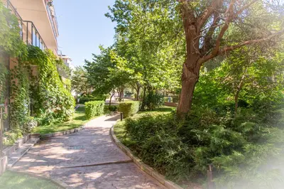 a sidewalk next to a building with a tree at Sozopoli Style Club in Sozopol