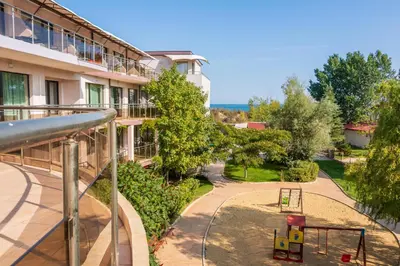 an apartment building with a playground in front of a building at Sozopoli Style Club in Sozopol