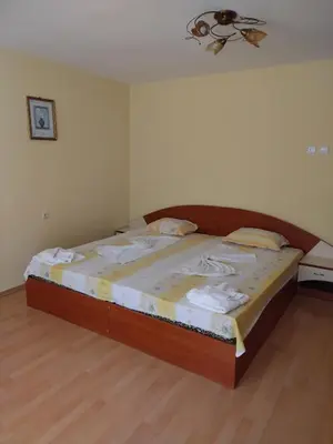 a large bed in a bedroom with a ceiling at Apart Hotel Hetodon in Sozopol