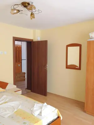 a bedroom with a bed and a mirror and a door at Apart Hotel Hetodon in Sozopol