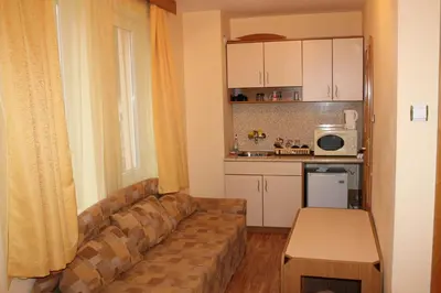 a living room with a couch and a kitchen at Apart Hotel Hetodon in Sozopol