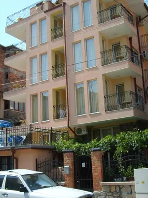 a tall building with balconies and a car parked in front at Apart Hotel Hetodon in Sozopol