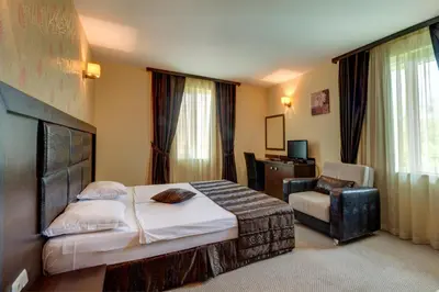 a hotel room with a bed and a chair at Siena House in Sozopol