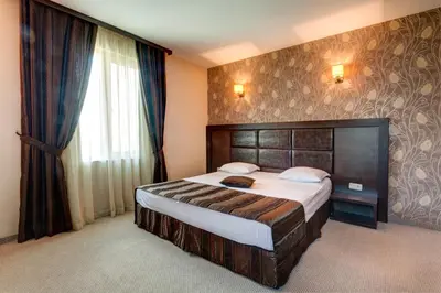 a bedroom with a large bed and a large window at Siena House in Sozopol