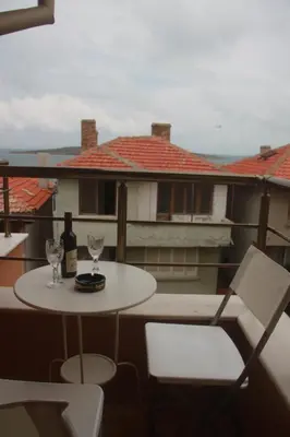 a table and two glasses of wine on a balcony at Family Hotel Emilia in Sozopol
