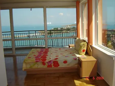 a room with a bed in front of a window at Panoramic Penthouse Sozopol in Sozopol