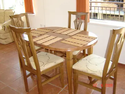 a wooden dining room table with four chairs and a window at Panoramic Penthouse Sozopol in Sozopol