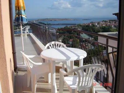 a white table and chairs on a balcony with a view at Panoramic Penthouse Sozopol in Sozopol