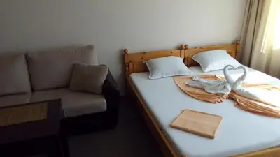 a bedroom with a bed with a chair and swan towels at Guest House Diamant in Sozopol