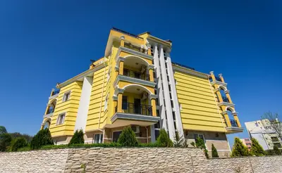 a yellow building on top of a stone wall at Hotel Luxor in Lozenets