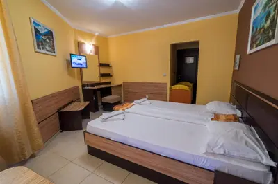 a bedroom with a large bed and a desk at Hotel Luxor in Lozenets