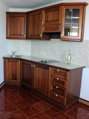 an empty kitchen with wooden cabinets and a sink at Helena VIP Villas and Suites - Half Board in Sunny Beach